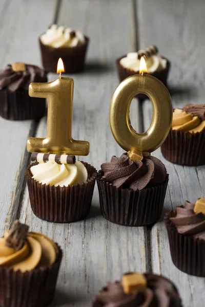 Número 10 celebração aniversário cupcakes em um fundo de madeira — Fotografia de Stock