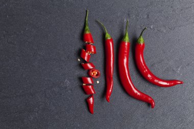 Kırmızı taze biber koyu bir kayrak backg üzerinde parçalar halinde doğranmış
