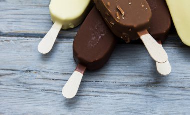 Ahşap bir arka plan üzerinde çikolatalı dondurma lollies.