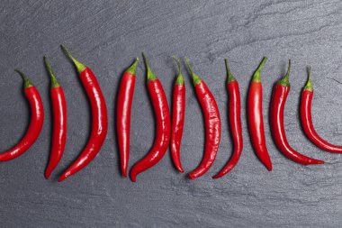 Koyu bir kayrak arka plan üzerinde kırmızı taze biber