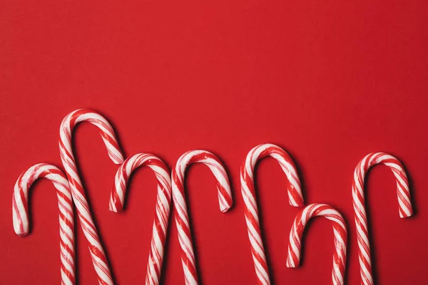 Christmas festlig godis sockerrör på en röd bakgrund — Stockfoto