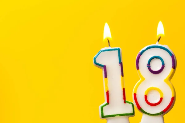 Číslo 18 narozeninová svíčka proti jasně žluté ba — Stock fotografie