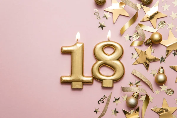 Number 18 gold celebration candle on star and glitter background — Stock Photo, Image