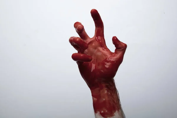 Véres kéz a világos háttér ellen. Halloween horror koncepció — Stock Fotó