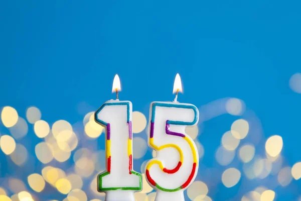 Numéro 15 anniversaire bougie de célébration contre une lumière vive et — Photo