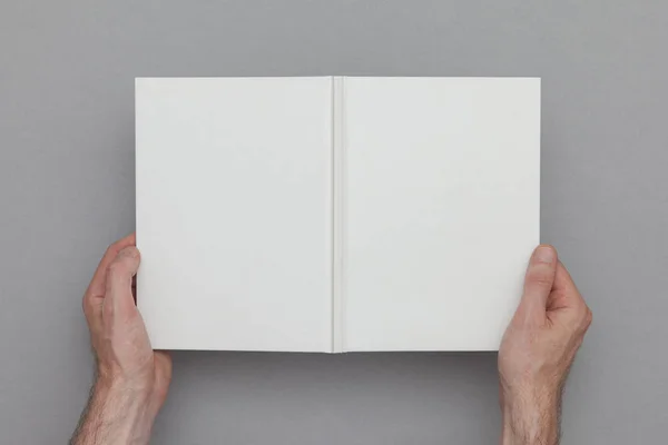 Mužská ruka držící otevřenou knihu s vyznačením potahy knih. Kniha moc — Stock fotografie