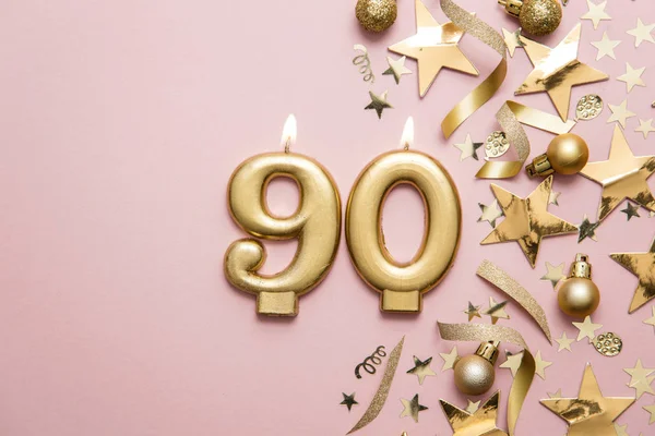 Bougie de célébration numéro 90 en or sur fond étoilé et scintillant — Photo