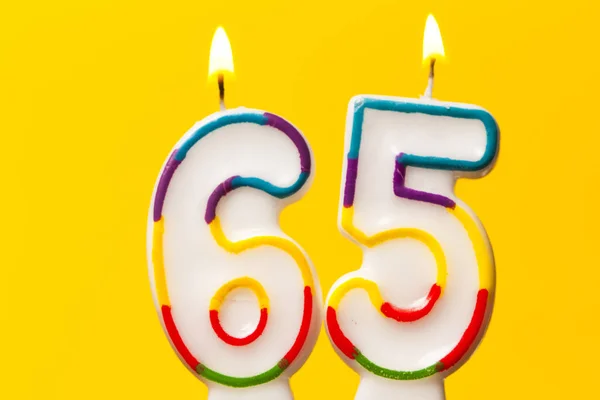 Sayı 65 parlak sarı ba karşı doğum günü kutlama mum — Stok fotoğraf