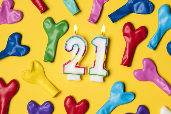Číslo 21 svíčka se stranické balónky na jasně žluté backgrou — Stock fotografie