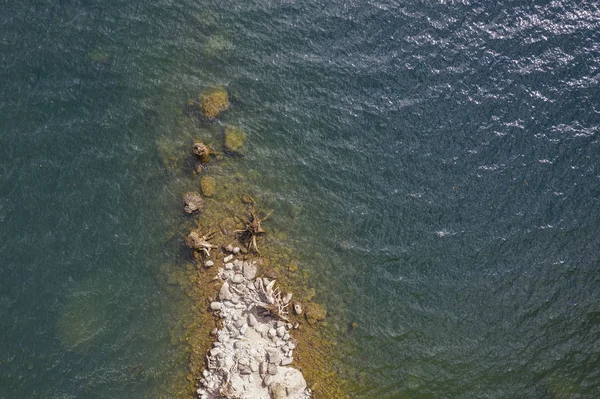 Натуральный каменистый пляжный слой с прозрачной водой — стоковое фото