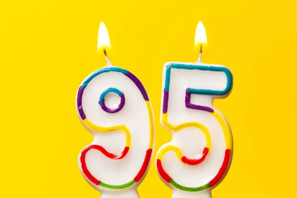 Numero 95 candela celebrazione di compleanno contro una brillante ba gialla — Foto Stock