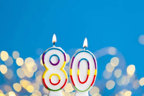 Número 80 vela de celebración de cumpleaños contra una luz brillante un —  Fotos de Stock