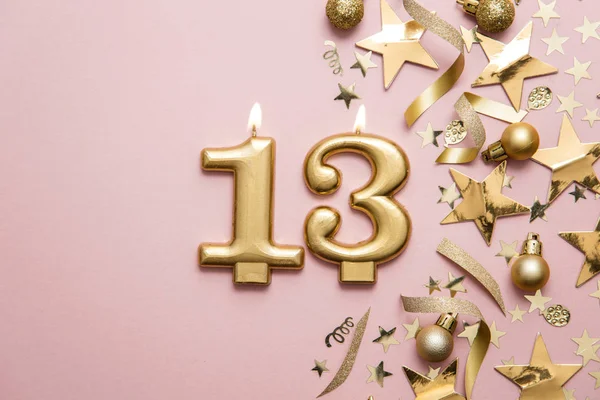 Number 13 gold celebration candle on star and glitter background — Stock Photo, Image