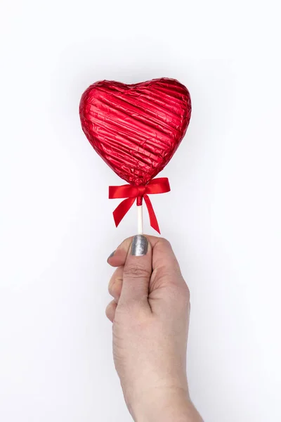 Regalo de San Valentín. Mano femenina sosteniendo un lolly en forma de corazón — Foto de Stock