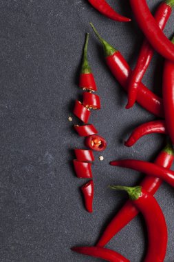 Kırmızı taze biber koyu bir kayrak backg üzerinde parçalar halinde doğranmış