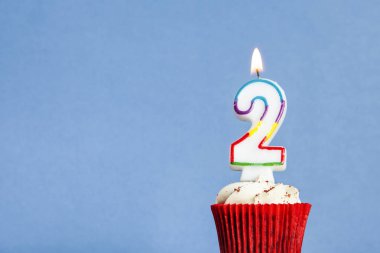 Mavi bir arka plan aleyhine bir cupcake Sayısı 2 doğum günü mum