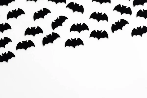Schwarze Fledermausformen auf weißem Hintergrund. Halloween-Hintergrund — Stockfoto