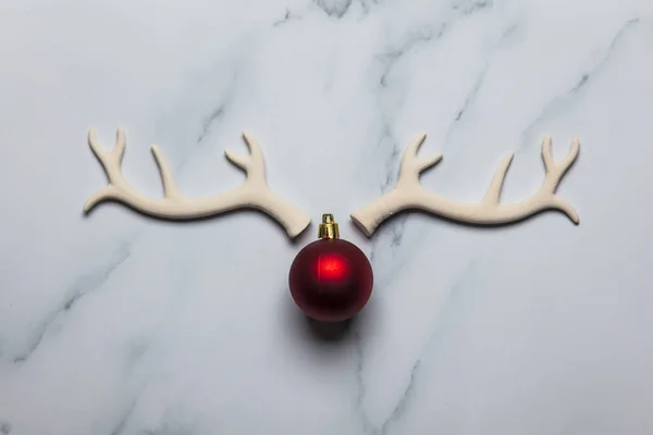 Cara de renos navideños hecha de astas y adornos sobre un mármol —  Fotos de Stock