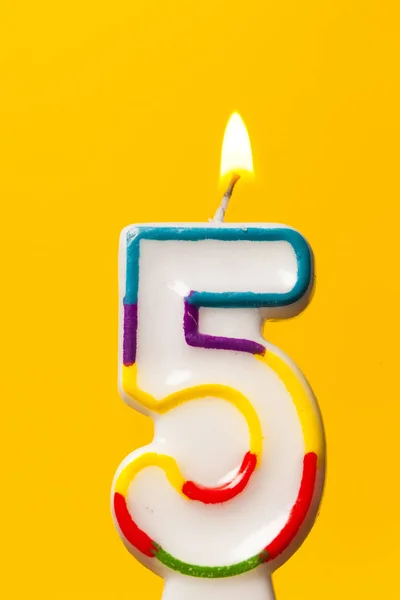 Number 5 birthday celebration candle against a bright yellow bac — Stock Photo, Image