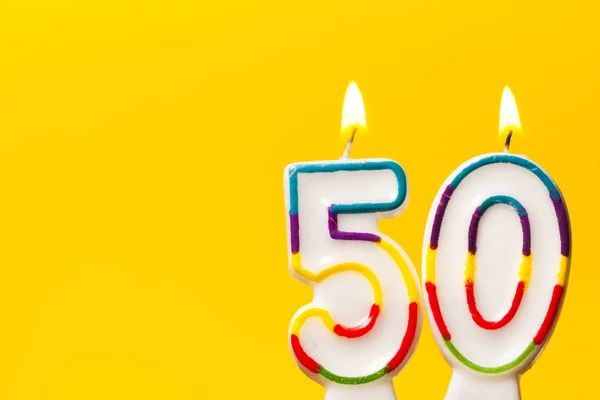 Numero 50 candela celebrazione di compleanno contro una brillante ba gialla — Foto Stock