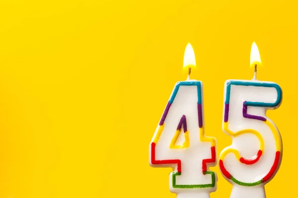 Numara 45 parlak sarı ba karşı doğum günü kutlama mum — Stok fotoğraf