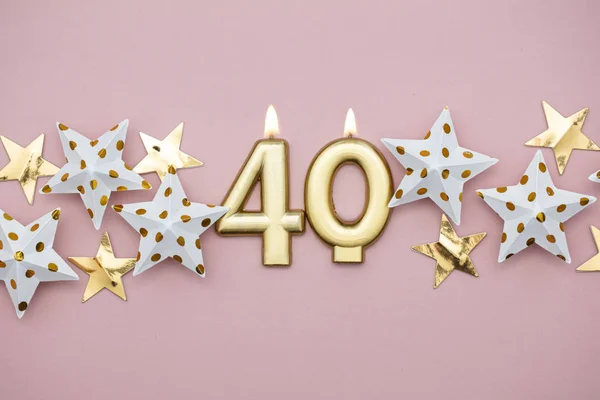 Číslo 40 zlaté svíčky a hvězdy na pastelově růžovém pozadí — Stock fotografie