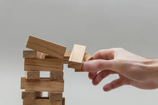 Male hand stacking wooden blocks. Business development and growt