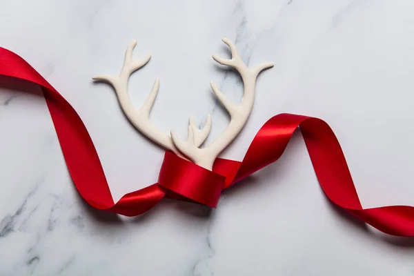 Feestelijke rendieren geweien en rode lint op een marmeren achtergrond — Stockfoto