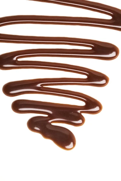 Ondulation de sauce au caramel au chocolat sur fond blanc uni — Photo