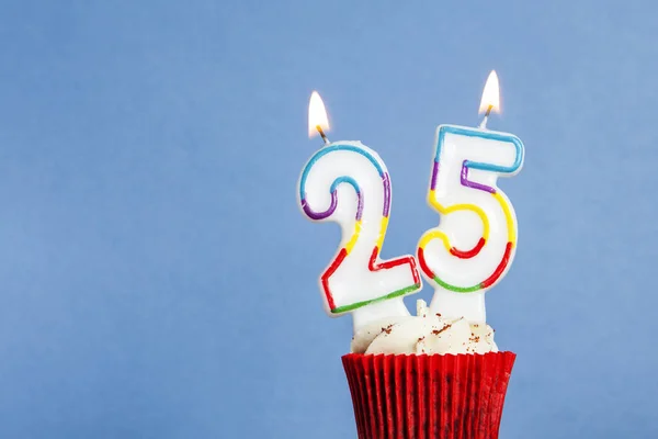 在蓝色背景的纸杯蛋糕中，25号生日蜡烛 — 图库照片