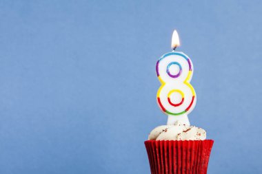 Mavi bir arka plan aleyhine bir cupcake sayısı 8 doğum günü mum