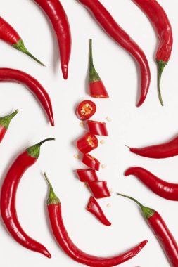 Dilimlenmiş kırmızı biber düz bir arka plan üzerinde düzenlenmiş