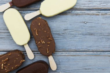 Ahşap bir arka plan üzerinde çikolatalı dondurma lollies.
