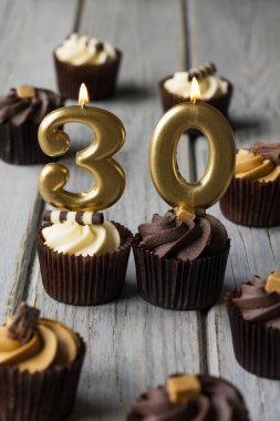 Ahşap bir arka plan üzerinde Sayısı 30 kutlama doğum günü cupcakes