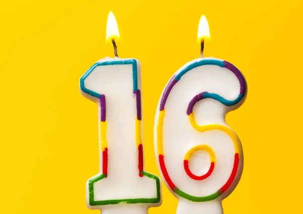Geburtstagskerze Nummer 16 vor leuchtend gelbem Ba — Stockfoto
