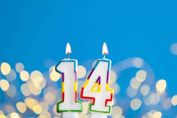 Numéro 14 anniversaire bougie de célébration contre une lumière vive et — Photo