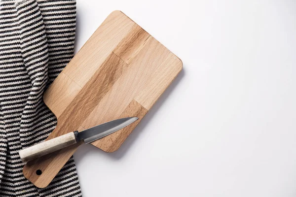 Wooden chopping board and knife with a striped cloth — Stock Photo, Image