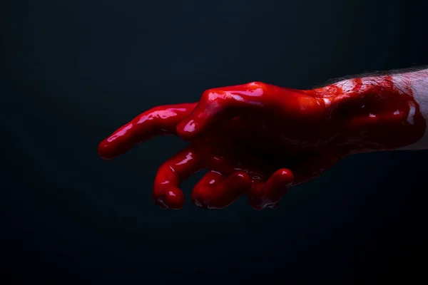 Mão ensanguentada contra um fundo escuro. halloween horror conceito — Fotografia de Stock