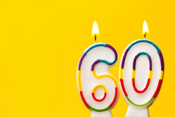 Número 60 vela de celebración de cumpleaños contra una ba de color amarillo brillante — Foto de Stock