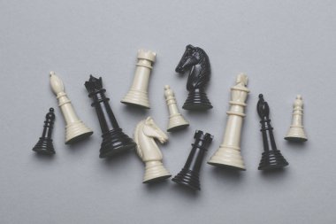 Gri bir arka plan üzerinde satranç oyunu parçaları. Strateji kavramı