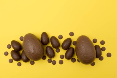 Parlak sarı arka planda çikolata Paskalya yumurtası. Paskalya Holi