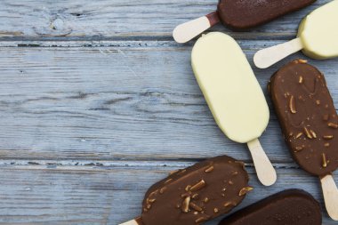 Ahşap bir arka plan üzerinde çikolatalı dondurma lollies.