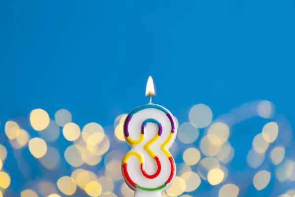 Number 3 birthday celebration candle against a bright lights and — Stock Photo, Image
