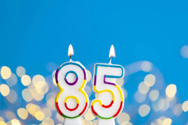 数字85生日庆祝蜡烛对明亮的灯光 — 图库照片