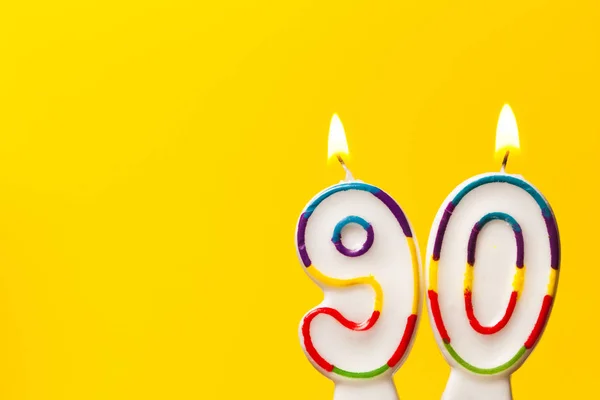 Numero 90 candela celebrazione di compleanno contro una brillante ba gialla — Foto Stock