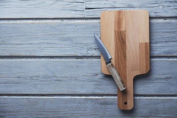 Planche à découper en bois et couteau sur une planche de bois rustique backgroun — Photo