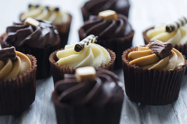 Gâteaux décorés de chocolat, de caramel et de glaçage à la vanille sur un — Photo