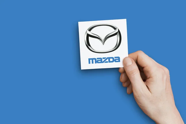 Londyn, Wielka Brytania-26 października 2018: ręka trzyma logo Mazda. Mazda — Zdjęcie stockowe