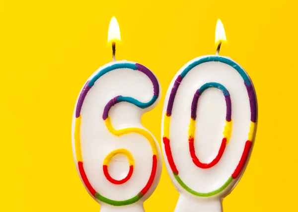 Número 60 vela de celebración de cumpleaños contra una ba de color amarillo brillante —  Fotos de Stock