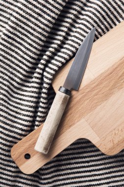 Çizgili bir bez ile ahşap doğrama tahtası ve bıçak